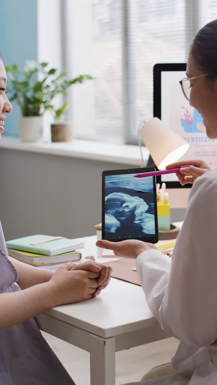Doctor showing ultrasound to pregnant woman