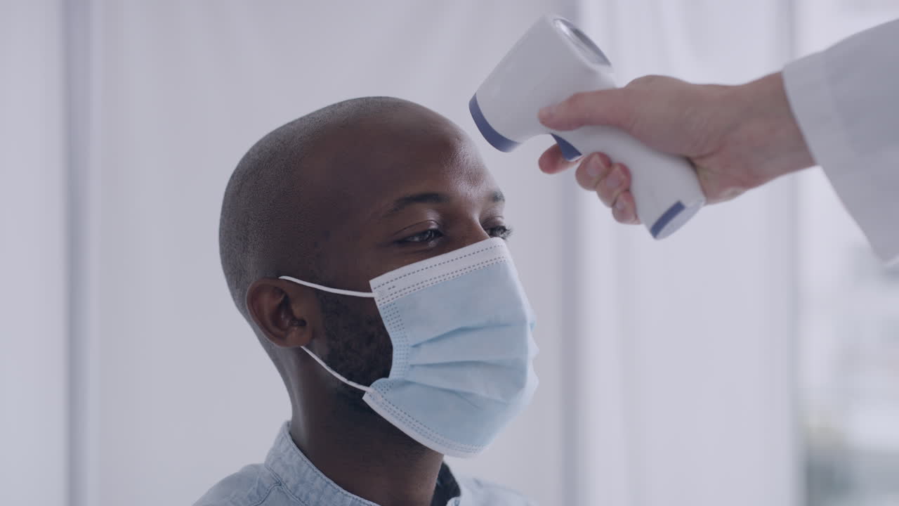 Man having his temperature checked while wearing