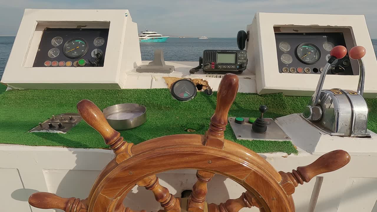 Steering Wheel and Navigation Compass on a Yacht Background of Red Sea
