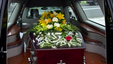 closeup shot of a funeral casket in a hearse or chapel or burial at cemetery