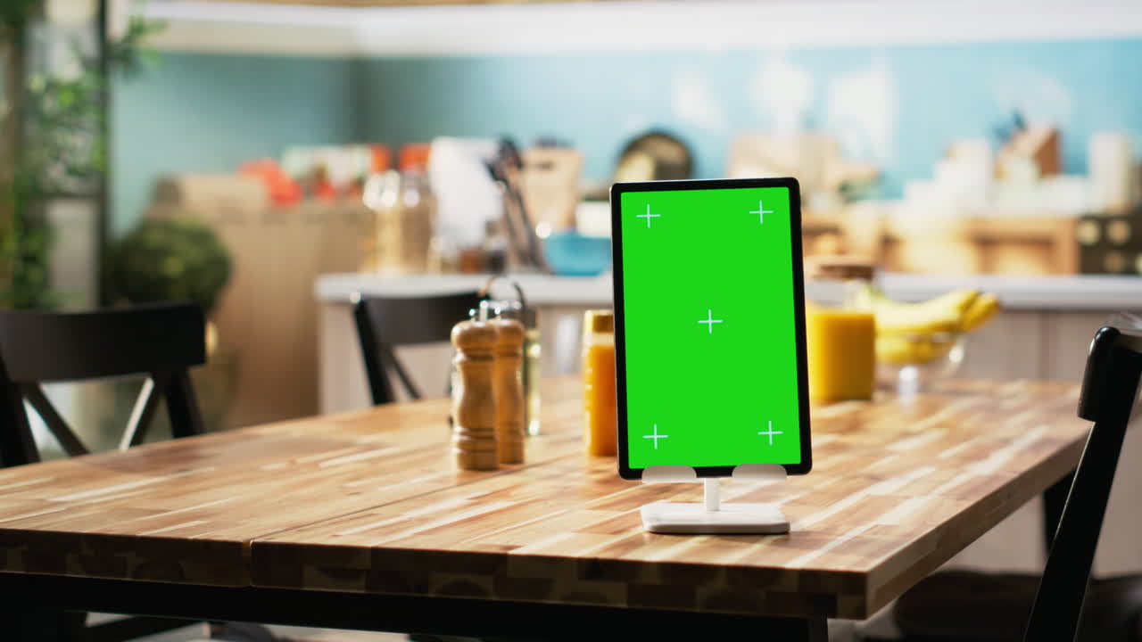 Vertical green screen on tablet in empty wooden stylish kitchen space