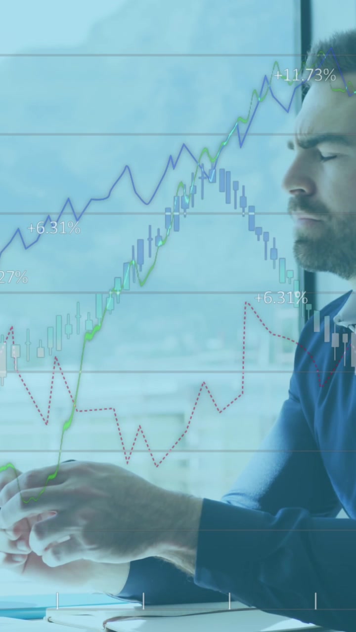 Animazione di dati finanziari e grafici su uomo d'affari caucasico concentrato in ufficio