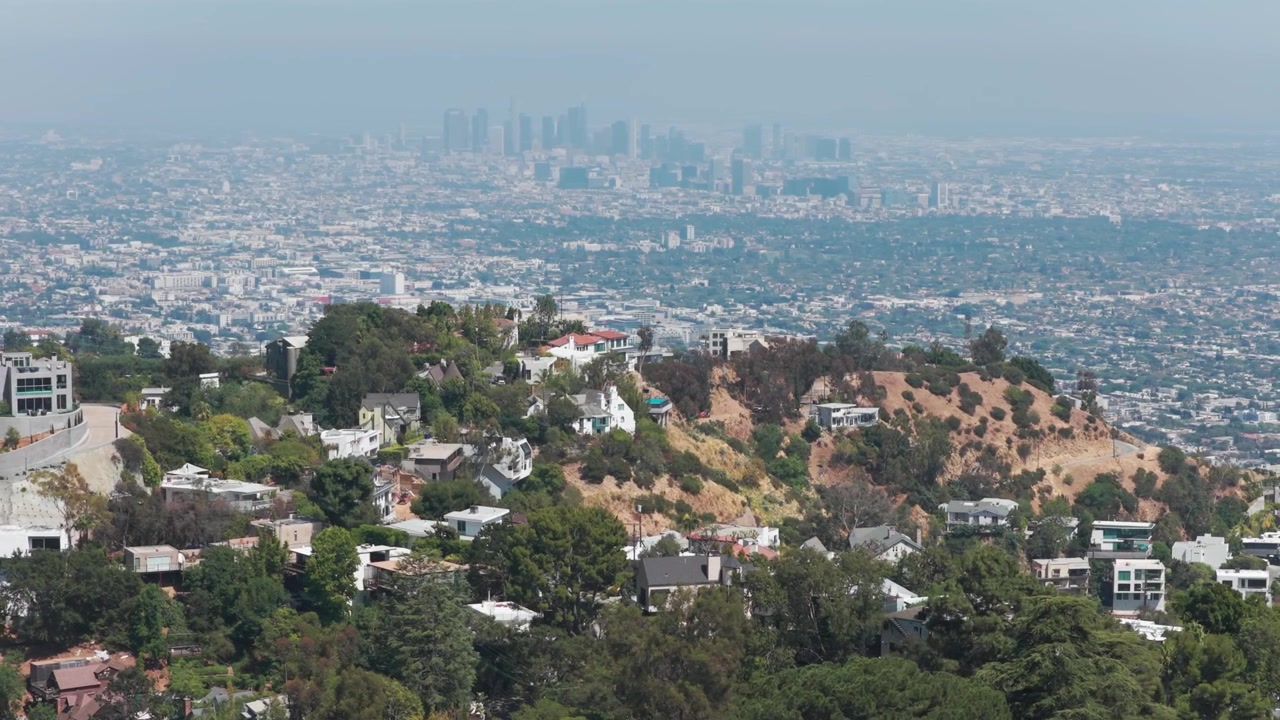 Ripresa aerea con dolly e teleobiettivo di Los Angeles dalle montagne sopra Beverly Hills, nella California meridionale. 4K.