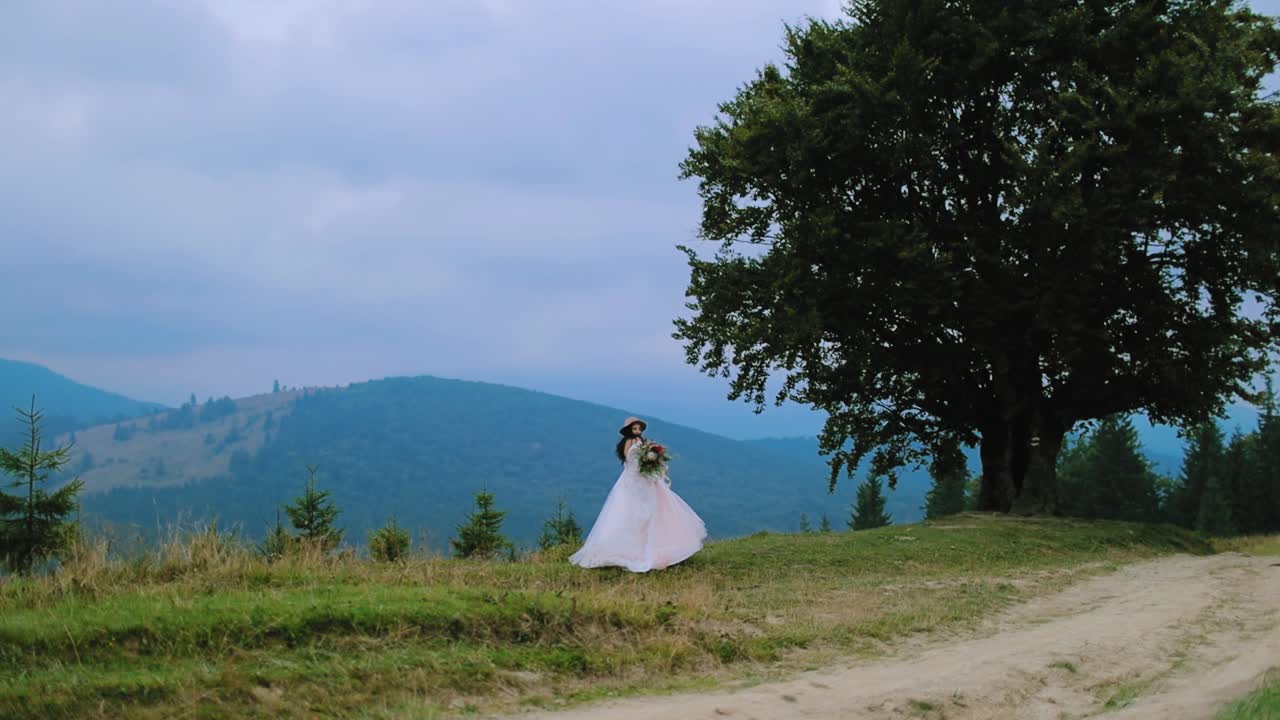 Bride in beautiful dress walking in mountainous area. Natural landscape in the mountains in summer and a woman in white wedding dress among nature.