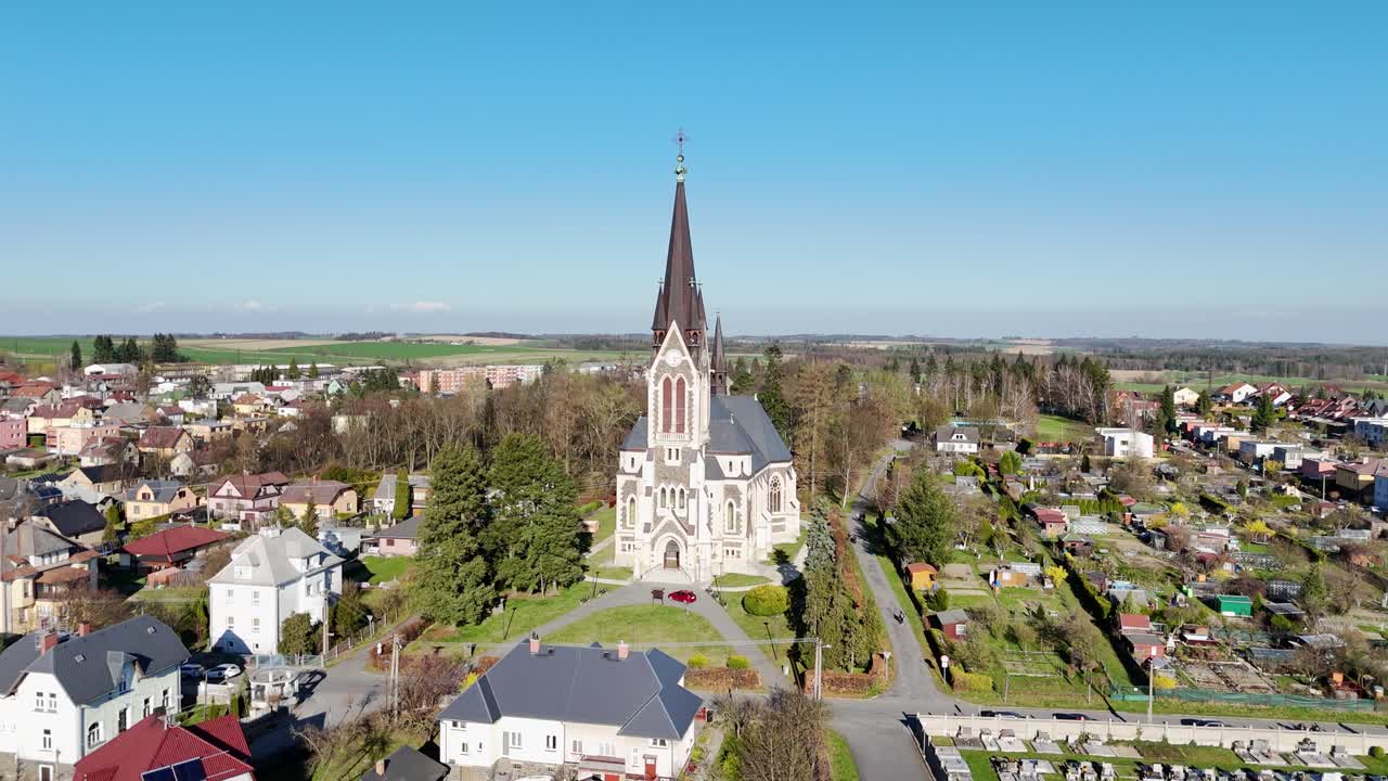 Aerial tracking orbit of Vitkov church complex and town under bright blue sky, Czech Republic