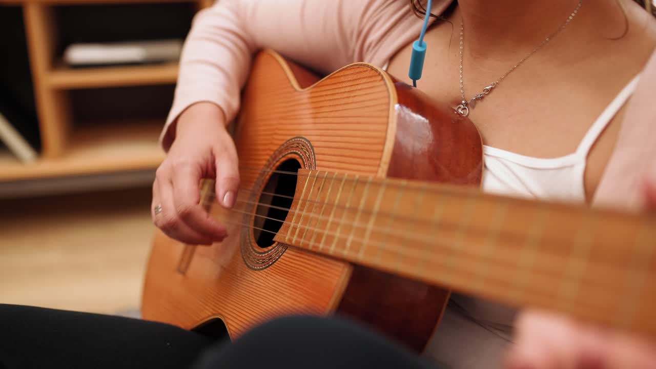 Woman playing acoustic guitar chords