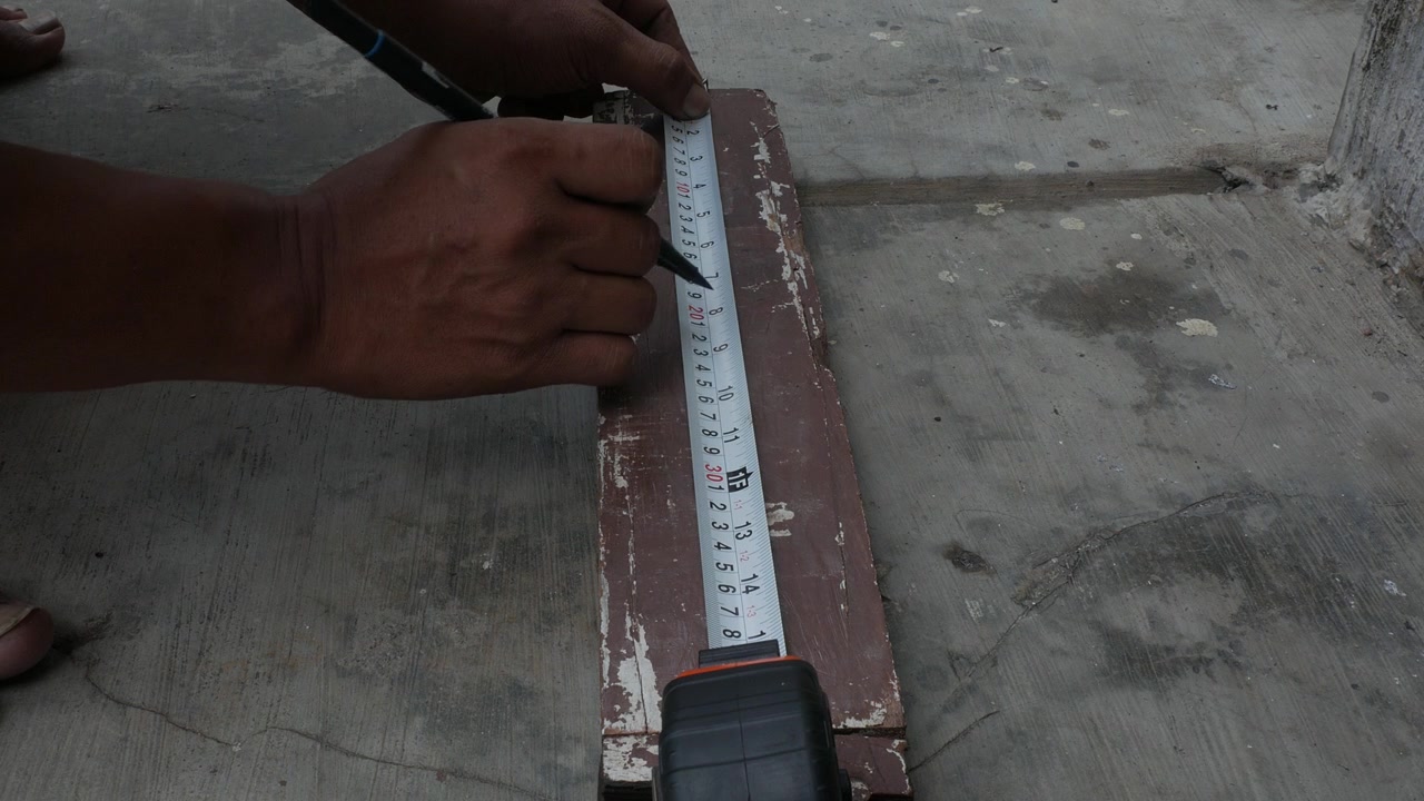 Marking Measurement Line on Wooden Board with Tape Measure