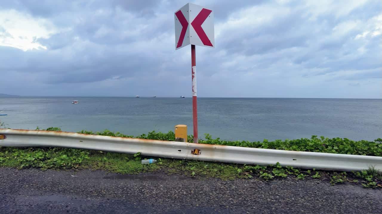 View of road by the seacoast just beyond the end of the runway at Caticlan Airport in Aklan, Philippines, that can also be used as driving plates footage viewed through the side window of a car