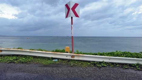 view of road by the seacoast just beyond the end of the runway at caticlan airport in aklan, philippines, that can also be used as driving plates footage viewed through the side window of a car