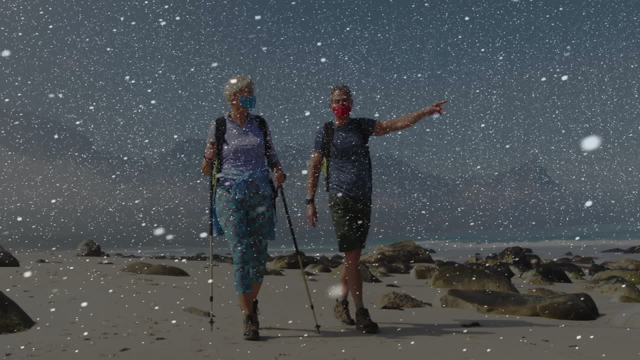 Caminhantes idosos caminhando por uma praia de areia, com um gráfico de fitness animado e um gráfico de frequência cardíaca.
