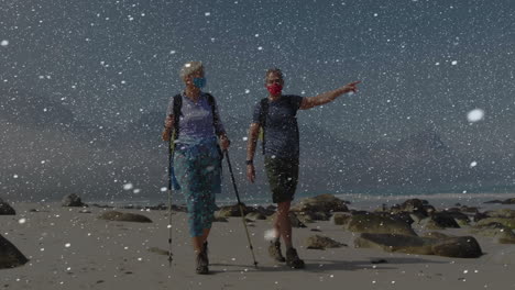 senior hikers walking along sandy beach, with animated fitness graph and heart rate chart