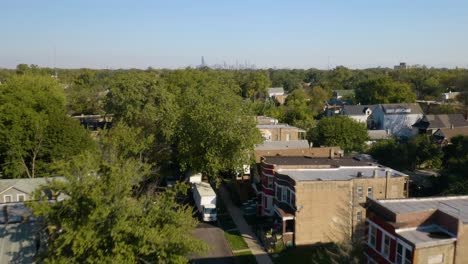 drone flying over poor south side neighborhood, reveals chicago skyline in summer