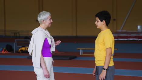 mujer mayor hablando con un niño en el interior