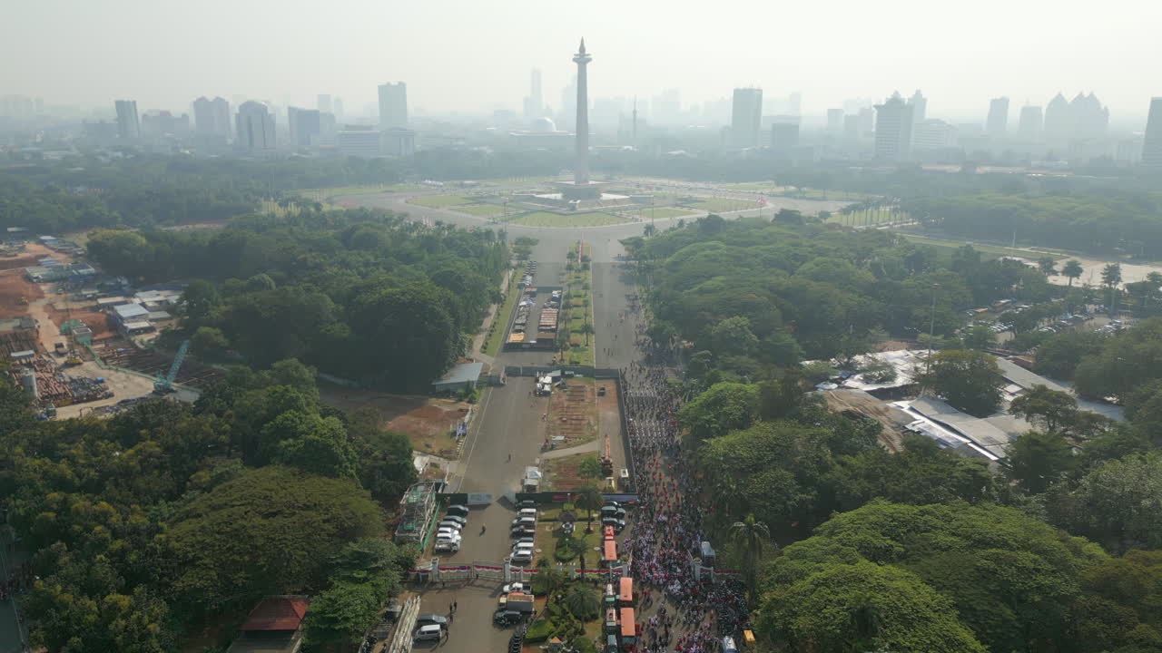 Parata dell'Indipendenza Marcia Verso la Statua di Monas nel Centro di Jakarta, Indonesia, Drone Statico 4K 60FPS