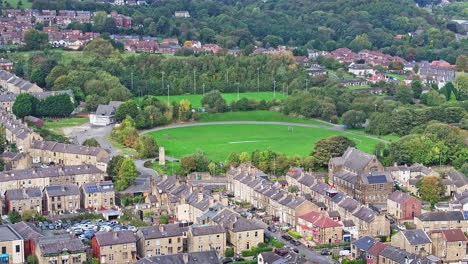 apartamentos icónicos alrededor de un campo de fútbol con hierba en huddersfield, inglaterra