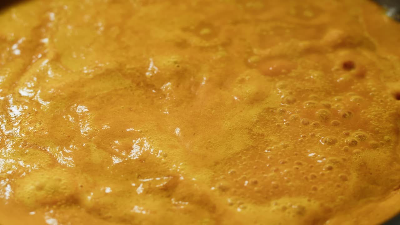 Yellow boiling sauce on pan close-up. Asian cuisine concept. Curry is a dish with a sauce seasoned with spices. Curries may contain fish, meat, poultry, or shellfish, either alone or in combination with vegetables. Others are vegetarian.