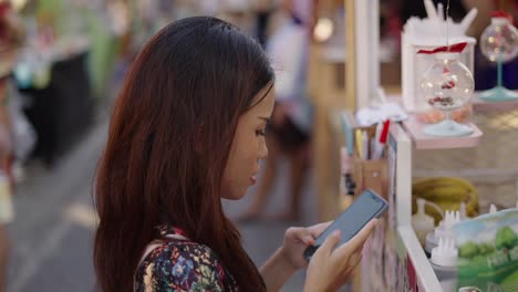 young woman using smartphone at a night market