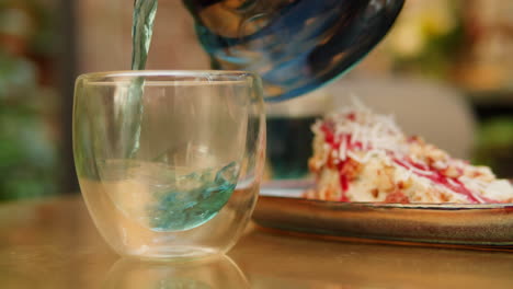 pouring tea or coffee over a glass with piece of cake