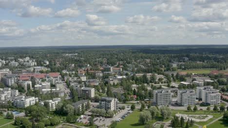 Slow-aerial-view-above-a-city-near-Helsinki,-Finland-with-cars-passing-quickly-on-the-road