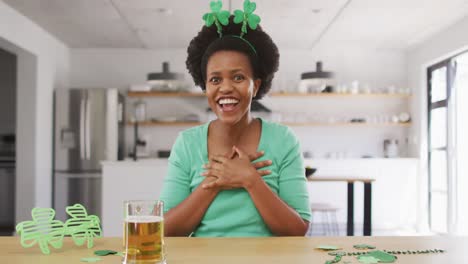 happy african american woman sitting at table,making video call