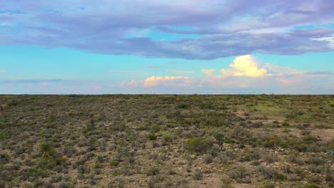 Drone-over-desert-with-clouds-and-low-brush