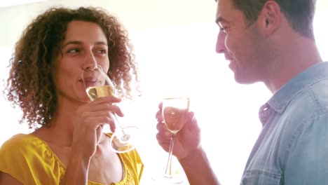 Cute-couple-toasting-with-champagne-in-the-living-room