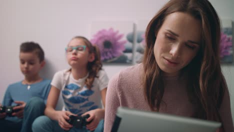 Mother-working-on-tablet-pc.-Woman-freelancer-working-at-home