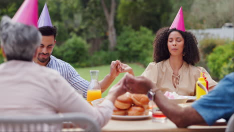 familia orando juntos durante la celebración del cumpleaños