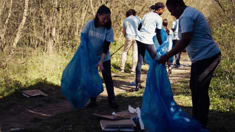 group of diverse volunteers collecting rubbish from the woods and recycling