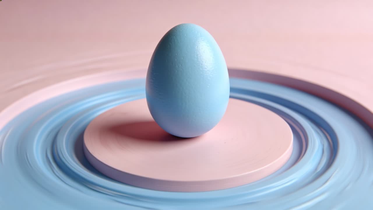 Balancing blue matte egg upright on pale-pink pedestal as concentric rings start shifting to ripple