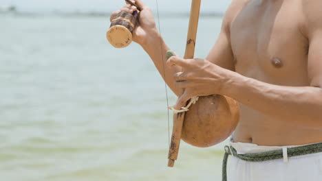 shirtless man playing instrument