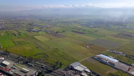 Vista-Aérea-De-Los-Campos-Agrícolas-Cerca-De-La-Ciudad-De-México-Y-Alrededor-De-Los-Volcanes