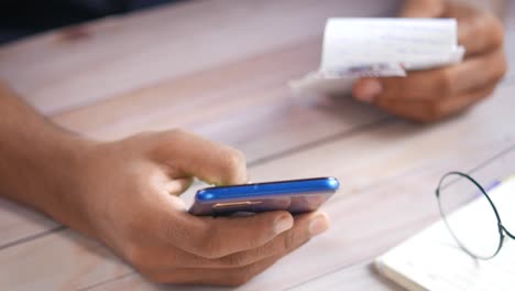 person using smartphone with documents