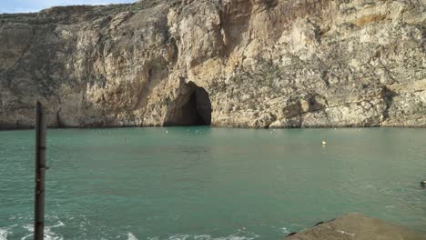 signo de superficie resbaladiza colocado cerca de cuevas marinas interiores en la isla de gozo
