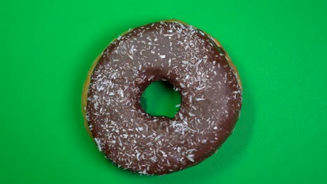 delicioso y fresco rosquilla de rosquilla macro disparo de primer plano girando sobre un fondo verde.