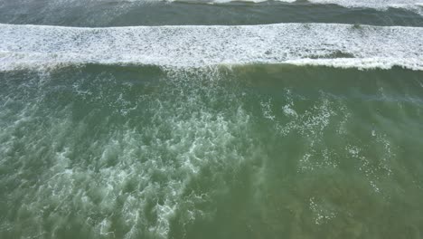 Aerial-Top-Down-View-of-Ocean-Rhythmic-Waves,-Immerse-yourself-in-the-captivating-dance-of-the-ocean-with-this-top-down-aerial-footage,-showcasing-the-rhythmic-waves-and-the-beauty-of-the-sea