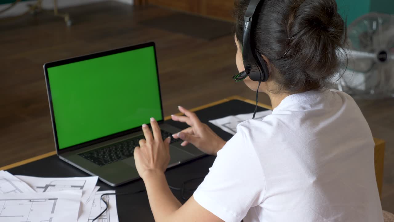 sobre el hombro de la mujer asiática mirando la pantalla verde. persona de la oficina usando una computadora portátil con pantalla verde
