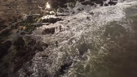 Surfer-entering-waters-of-Atlantic-Ocean-walking-among