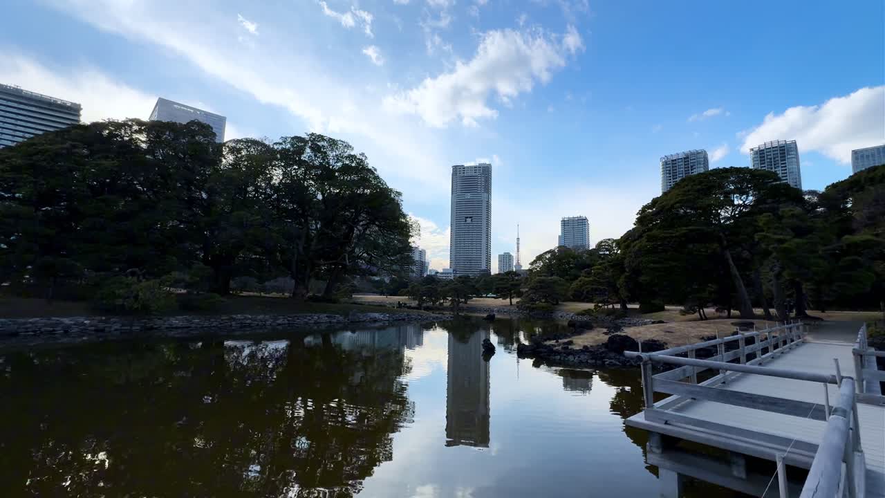 A peaceful pond reflecting skyscrapers and trees in Hama Rikyu Gardens, Tokyo