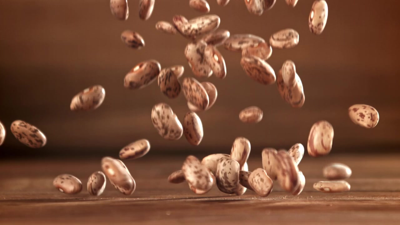 Pinto Beans Falling and Bouncing on a Wooden Surface in Slow Motion