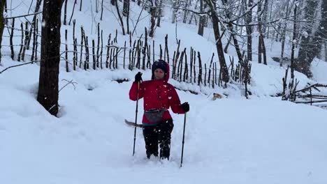 caminar duro en la nieve pesada en invierno en el bosque de hyrcanian paisaje de invierno nevada en la naturaleza maravillosa aldea rural trekking poste chaqueta de color rojo y pantalones negros persona de senderismo solo irán