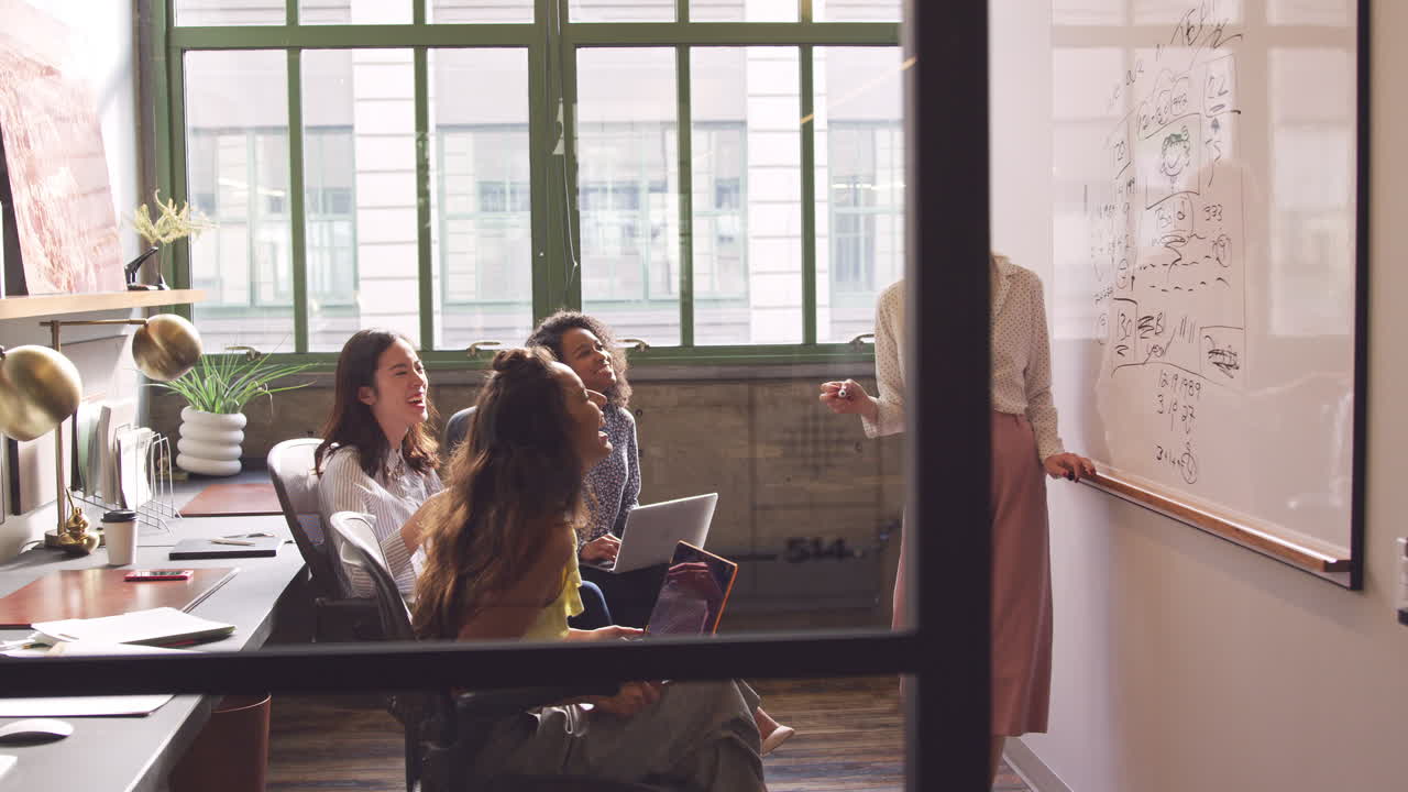 네 명의 여성 크리에이티브가 사무실에서 브레인스토밍을 하고 있습니다.