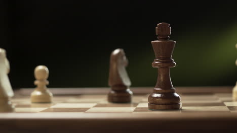 hand moves chesspiece queen to king in cinematic chess shot, making checkmate in chessgame, falling king