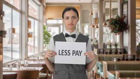 sad indian woman waiter holding less pay banner