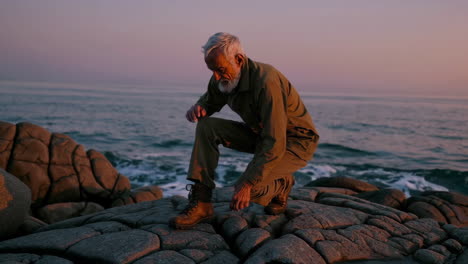 senior man on the rocks at sunrise