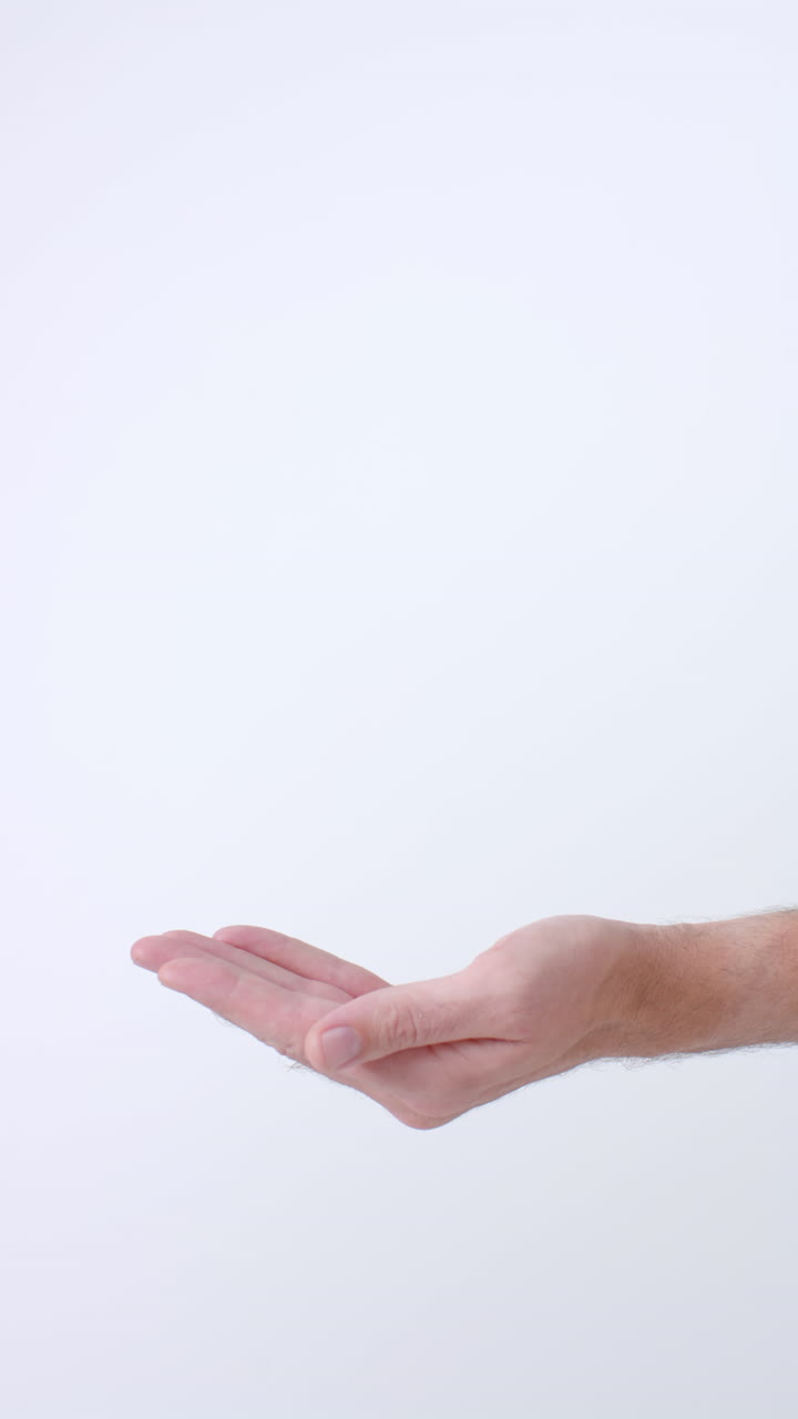 Vertical video of hands of diverse people giving blood drop on white background, slow motion