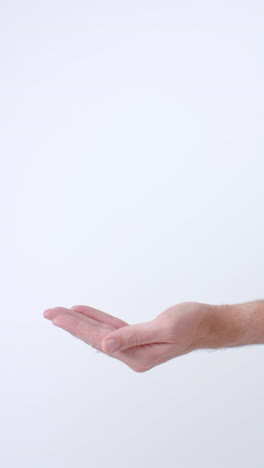 vertical video of hands of diverse people giving blood drop on white background, slow motion