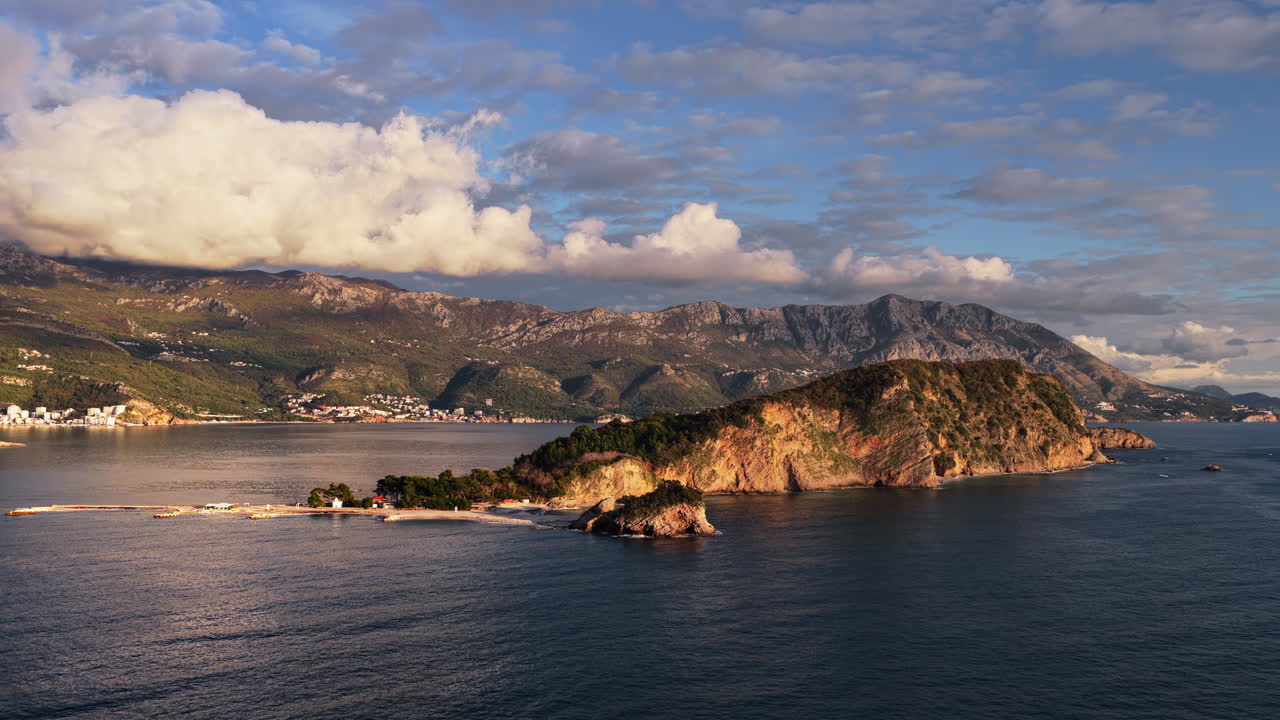 Aerial drone view of Mogren or Slovenska Plaza area, showing a rocky peninsula jutting into the sea. Montenegro