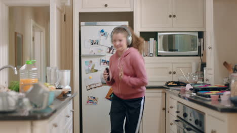 happy-teenage-girl-dancing-in-kitchen-having-fun-celebrating-weekend-performing-funny-dance-moves-listening-to-music-wearing-headphones