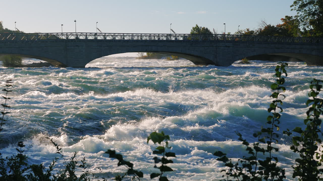 나이아가라 폭포와 관광객들이 걷는 나이아가라 강 건너 다리